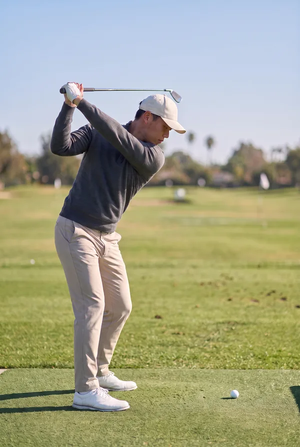 His best 7-iron swing: the top of the backswing, with the club parallel to the ground.